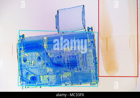 X-ray screenshot of a box with a spray bottle, a bottle of water and a laptop. Stock Photo