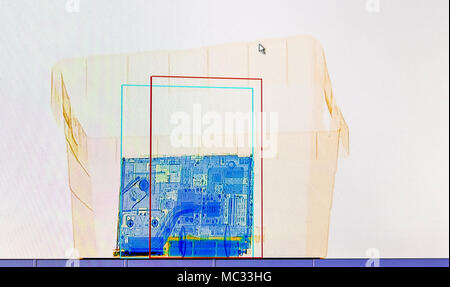 X-ray screenshot of a box with a spray bottle, a bottle of water and a laptop. Stock Photo