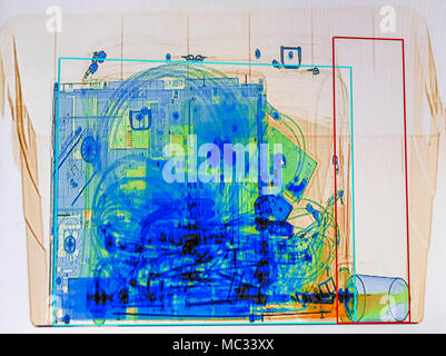 X-ray screenshot of a box with a spray bottle, a bottle of water, a laptop and a camera bag. Stock Photo