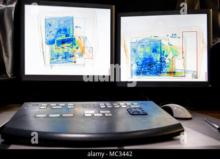 X-ray system scanning of a box with a spray bottle, a bottle of water, a laptop and a camera bag. Stock Photo