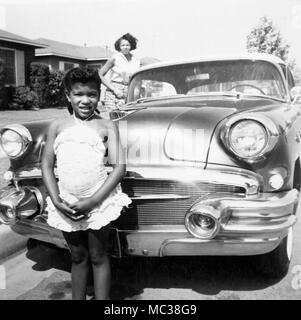 A little girl and her mother stand by the family car in California, 1958. Stock Photo