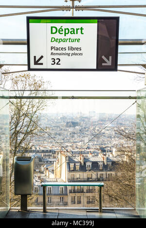 View over the rooftops of Paris from the upper station of the Montmartre funicular railway with a multilingual information screen in the foreground. Stock Photo