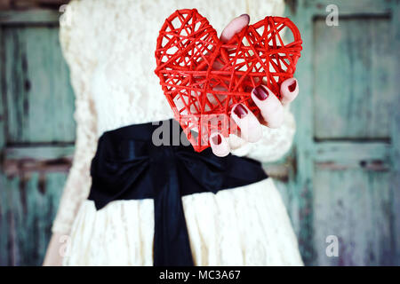 Beautiful young woman holding a red heart Stock Photo
