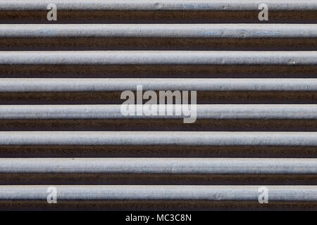 Metal shutter door, gray color with rust running from humidity, texture backdrop. Stock Photo