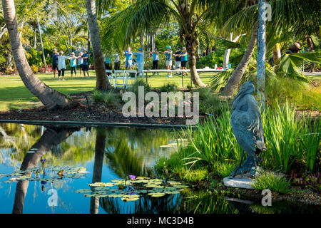 Tai Chi class on the lawn by a pond at Naples Botanical Gardens, Naples, Florida, USA Stock Photo
