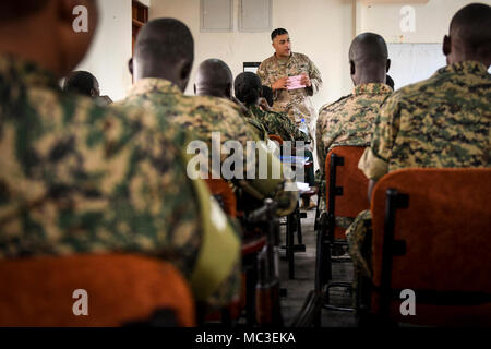 U.S. Army Staff Sgt. Damon Boxley, team sergeant from Charlie Company, 443rd Civil Affairs Battalion deployed to Combined Joint Task Force-Horn of Africa (CJTF-HOA), teaches the Civil Military Cooperation Civil Affairs Tactical Company Course (CCTCC) material to members of the Ugandan People's Defense Force in Uganda, Africa, Feb. 16, 2018. The training is designed to enhance the UPDF's capability and capacity to support its enduring African Union peacekeeping force and African Union Mission in Somalia mandates. Stock Photo