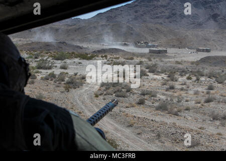 U.S. Marine Sgt. Caleb Bastille, a flight crew chief, fires a .50 caliber heavy machinegun during Air to Ground refinement in support of Weapons and Tactics Instructors course 2-18 at Marine Corps Air Station Yuma, Yuma, Ariz., April 2. WTI is a seven-week training event hosted by Marine Aviation Weapons and Tactics Squadron 1 cadre, which emphasizes operational integration of the six functions of Marine Corps aviation in support of a Marine Air Ground Task Force and provides standardized advanced tactical training and certification of unit instructor qualifications to support Marine Aviation  Stock Photo