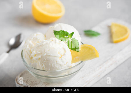 Lemon Ice Cream in bowl. Homemade citrus lemon ice cream with mint close up. Stock Photo