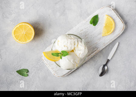 Lemon Ice Cream in bowl. Homemade citrus lemon ice cream with mint close up. Stock Photo