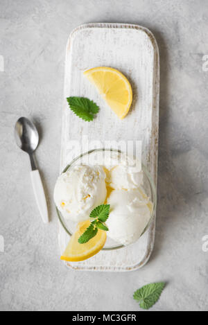 Lemon Ice Cream in bowl. Homemade citrus lemon ice cream with mint close up. Stock Photo