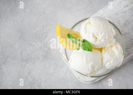 Lemon Ice Cream in bowl. Homemade citrus lemon ice cream with mint close up. Stock Photo