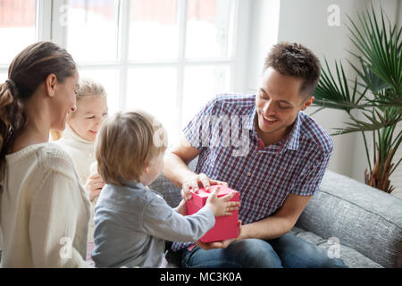Little children surprise her parents by gift box. Mom and Dad in house  concept. Family theme Stock Photo - Alamy
