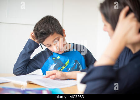 Private tutoring at home-10-11 years boy  having a maths lesson at home-selective focus Stock Photo