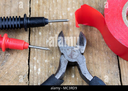 Accessories in the electronics workshop. Electronic meter, soldering iron and other tools needed for repairs of electronic devices. Dark background. Stock Photo