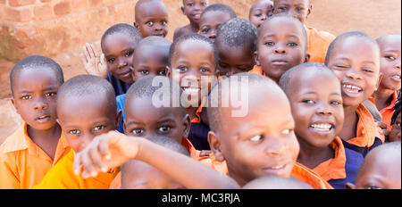 Uganda. June 13 2017. A group of happy primary-school children smiling, laughing and waving at a primary school. Stock Photo