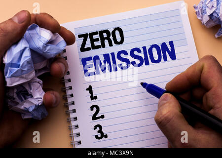 Handwriting text Zero Emission. Concept meaning Engine Motor Energy Source that emits no waste products written by Man on Notebook Book Holding Marker on the plain background. Stock Photo