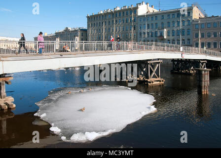 SAINT - PETERSBURG, RUSSIA - APRIL 12, 2018: People look at the ducks floating on the ice floe. Gorstkin Bridge over Fontanka River Stock Photo