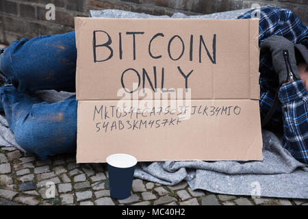 Beggar Sleeping On Street With Bitcoin Only Text On Cardboard Stock Photo