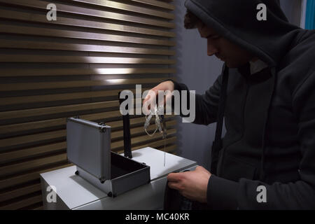 Close-up Of A Thief In Hoodie Stealing Jewelry Stock Photo