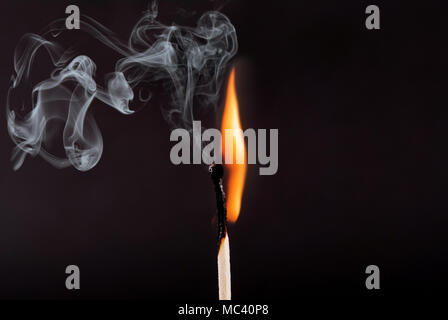 Matches stick with the flame and smoke burning, isolated on a black background Stock Photo