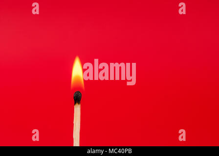 Matchstick burned with flame on red background, close up Stock Photo
