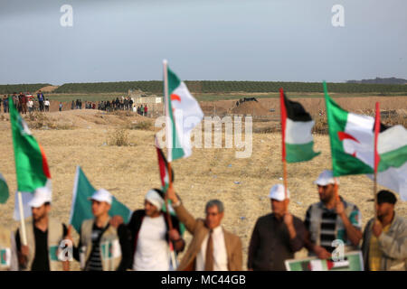 Gaza, Gaza Strip, Palestinian Territory. 12th Apr, 2018. Palestinians wave the national flag and flags of Algeria next to the Gaza border with Israel, east of Gaza, Gaza Strip, 12 April 2018. The protest is named ''The Great March of Return'' to mark the annual Land Day, which commemorates events that took place on 30 March 1976, when Israel expropriated Arab lands in Galilee and killed six unarmed Arab citizens Credit: Dawoud Abo Alkas/APA Images/ZUMA Wire/Alamy Live News Stock Photo