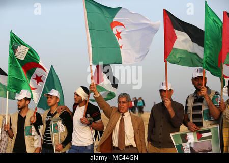 Gaza, Gaza Strip, Palestinian Territory. 12th Apr, 2018. Palestinians wave the national flag and flags of Algeria next to the Gaza border with Israel, east of Gaza, Gaza Strip, 12 April 2018. The protest is named ''The Great March of Return'' to mark the annual Land Day, which commemorates events that took place on 30 March 1976, when Israel expropriated Arab lands in Galilee and killed six unarmed Arab citizens Credit: Dawoud Abo Alkas/APA Images/ZUMA Wire/Alamy Live News Stock Photo
