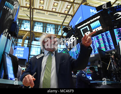 New York, USA. 12th Apr, 2018. A trader works at the New York Stock Exchange in New York, the United States, on April 12, 2018. U.S. stocks closed higher on Thursday. The Dow Jones Industrial Average gained 293.60 points, or 1.21 percent, to 24,483.05. The S&P 500 rose 21.80 points, or 0.83 percent, to 2,663.99. The Nasdaq Composite Index was up 71.22 points, or 1.01 percent, to 7,140.25. Credit: Li Rui/Xinhua/Alamy Live News Stock Photo