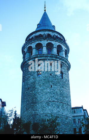Galata Tower in the old city of Istanbul standing tall in fading daylight with a lit window Stock Photo