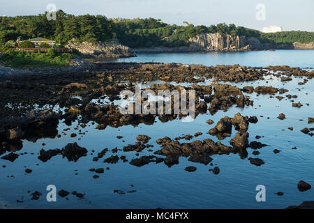 Along the coast of Seogwipo, fishermen at sunset in front of beautiful cliff, Seogwipo, Jeju Island, South Korea Stock Photo