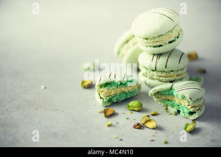 Green mint french macaroons with pistachios. Pastel colors macarons, copy space. Holidays and celebrations concept. Sweet gift for woman, girl Stock Photo