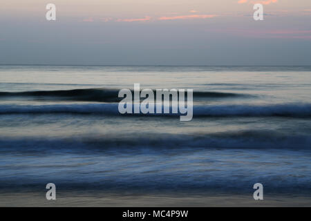 Emotionally powerful ocean sunrise with blurred waves Stock Photo