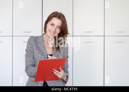 Busy female office worker going to make notes. Stock Photo