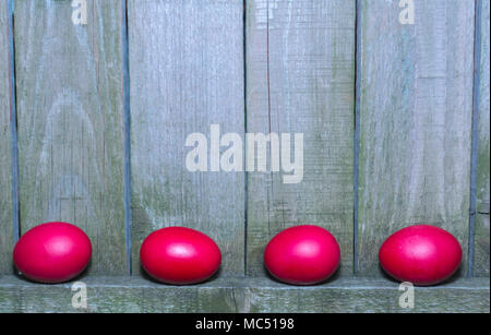 Red Easter eggs on rustic wooden fence background  Chicken eggs in red color and wooden fence Stock Photo