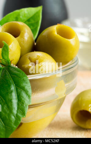 Green marinated olives pitted adorned with green leaves with shallow depth of focus Stock Photo