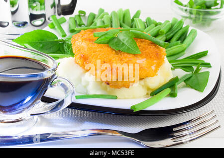 Close-up view of fried chicken, mashed potatoes and green beans with leek Stock Photo