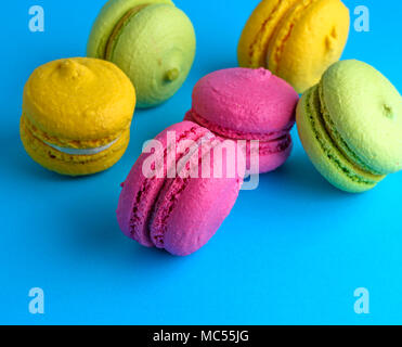 multicolored cakes of almond flour with cream, macarons on a blue background Stock Photo