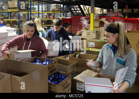 Students from St. Stephens Lutheran School turn donated goodies from North Carolina businesses into care packages at Hackney Service Merchandisers in Hickory, North Carolina for deployed North Carolina National Guard Soldiers via the NCNG Soldiers & Airmen Assistance Fund, Jan. 31, 2018. Members of Soldiers and Airmen Fund and retired NCNG leaders Air National Guard Col. Steven Martin and Army National Guard Sgt. Maj. Dennis Roach and Col. Drew Goodwin helped plan the event with Hickory businessman and retired Army Reserve Command Sgt. Maj. Dean Cline Sr. Hackney provided storage space for the Stock Photo