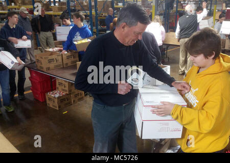 Students from St. Stephens Lutheran School turn donated goodies from North Carolina businesses into care packages at Hackney Service Merchandisers in Hickory, North Carolina for deployed North Carolina National Guard Soldiers via the NCNG Soldiers & Airmen Assistance Fund, Jan. 31, 2018. Members of Soldiers and Airmen Fund and retired NCNG leaders Air National Guard Col. Steven Martin and Army National Guard Sgt. Maj. Dennis Roach and Col. Drew Goodwin helped plan the event with Hickory businessman and retired Army Reserve Command Sgt. Maj. Dean Cline Sr. Hackney provided storage space for the Stock Photo