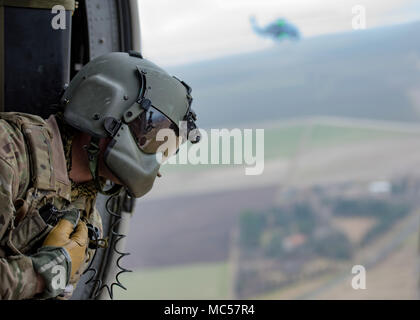 A special mission aviator assigned to the 56th Rescue Squadron leans out of an HH-60G Pave Hawk helicopter near Aviano Air Base, Italy, during a routine training mission Jan. 26, 2018. Members from the 56th and 57th RQS are flying throughout the region during several different training sorties. Their presence within the area will increase as they begin to transition from Royal Air Force Base Lakenheath, England. About 350 personnel, five HH-60G Pave Hawk helicopters are expected to relocate to Aviano AB in an effort to establish an enduring personnel recovery location within Europe.  (U.S. Air Stock Photo