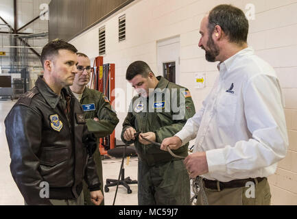 Senior Master Sgt. Jeff Witherly, Headquarters, Air Mobility Command C-17 evaluator loadmaster, Scott AFB, Ill.; Master Sgts. David Feaster and Elliott McClanahan, both 3rd Airlift Squadron loadmasters; listen to Justin Smoak, Samson Rope application engineering manager, Ferndale, Wash., talk about the construction of the winch cable Jan. 30, 2018 at Dover Air Force Base, Del. The 280-foot long steel cable currently used on C-17 Globemaster III aircraft winches weigh 80 pounds versus the proposed synthetic winch cable only weighing 14 pounds. (U.S. Air Force photo by Roland Balik) Stock Photo