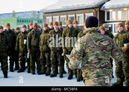 A United Kingdom Royal Marine briefs U.S. Marines with Marine Rotational Force 17.2 on the training schedule for the day during exercise White Claymore in Bardufoss, Norway, Jan. 29, 2018. White Claymore is a joint bi-lateral arctic cold weather training package led by the United Kingdom Royal Marines to train and evaluate proficiency in cold weather operations and enhance strategic cooperation and partnership between the U.S. Marines and U.K. Royal Marines. (U.S. Marine Corps photo by Cpl. Careaf L. Henson/Released) Stock Photo