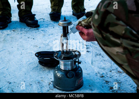 A United Kingdom Royal Marine briefs U.S. Marines with Marine Rotational Force 17.2 on how to properly utilize a lantern during exercise White Claymore in Bardufoss, Norway, Jan. 29, 2018. White Claymore is a joint bi-lateral arctic cold weather training package led by the United Kingdom Royal Marines to train and evaluate proficiency in cold weather operations and enhance strategic cooperation and partnership between the U.S. Marines and U.K. Royal Marines. (U.S. Marine Corps photo by Cpl. Careaf L. Henson/Released) Stock Photo
