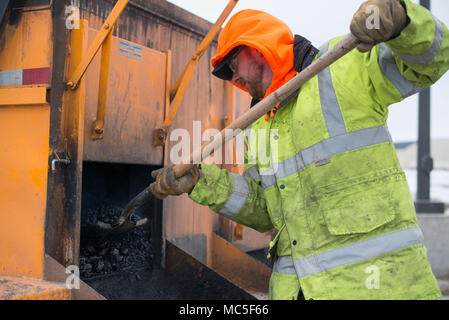 773rd Civil Engineer Squadron is a United States Air Force unit responsible for installation infrastructure maintenance and engineering support at Joint Base Elmendorf-Richardson. The archival image records pothole repair work using asphalt during seasonal roadway maintenance operations conducted in Alaska in April 2018. Stock Photo