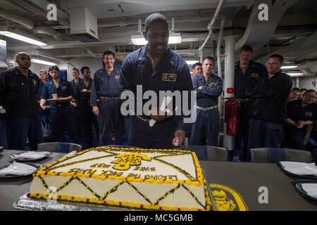 180401-N-GR847-0266 PACIFIC OCEAN (April 1, 2018) Chief Engineman Walter Williams, assigned to Whidbey Island-class dock landing ship USS Rushmore (LSD 47), cuts a cake in celebration of the Navy Chief’s 125th birthday during an amphibious squadron and Marine expeditionary unit (MEU) integration (PMINT) exercise. PMINT is a training evolution between Essex Amphibious Ready Group and 13th MEU, which allows Sailors and Marines to train as a cohesive unit in preparation for their upcoming deployment. (U.S. Navy photo by Mass Communication Specialist 3rd Class Reymundo A. Villegas III/Released) Stock Photo