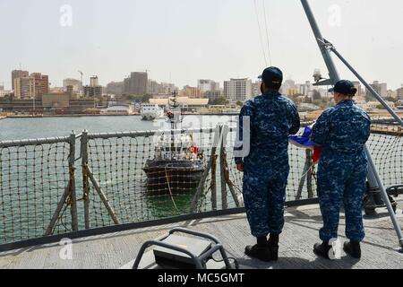 180405-N-QR145-029 DAKAR, Senegal (April 5, 2018) Ship's Serviceman 1st Class James Terry, left, and Ship's Serviceman 2nd Class Sarah Brooks prepare to raise the American flag aboard the Blue Ridge-class command and control ship USS Mount Whitney (LCC 20) as the ship arrives in Dakar, Senegal, April 5, 2018. Mount Whitney, forward-deployed to Gaeta, Italy, operates with a combined crew of U.S. Navy Sailors and Military Sealift Command civil service mariners. (U.S. Navy photo by Mass Communication Specialist 3rd Class Krystina Coffey/Released) Stock Photo