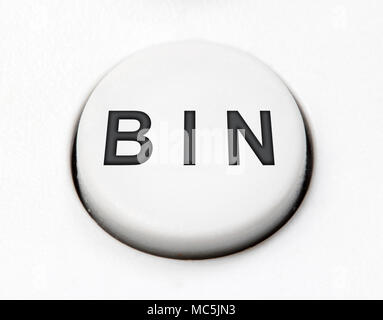 A white round button switch - bin, close up. Control mechanical key for delete on control device. Stock Photo