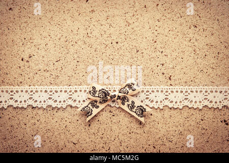 Retro lace and bow over real hand made paper background. Stock Photo