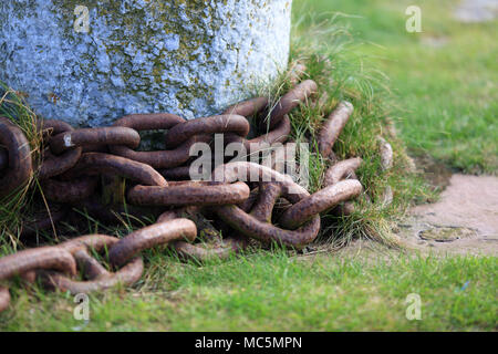 Rusty chains around a mooring post in a Scottish harbour, uk. Stock Photo