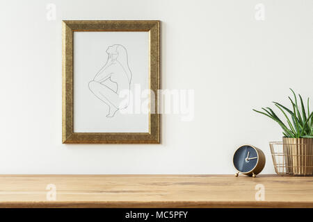 Golden alarm clock and a aloe in a basket on a shelf and a line drawing art in a frame on a white empty wall Stock Photo